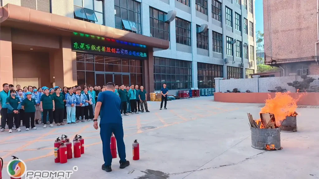Fire drill preparation at Padmat Rubber factory with fire extinguishers and burning barrel