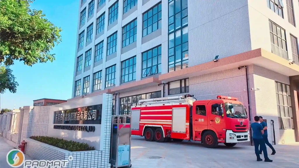 Fire truck parked at Padmat Rubber factory entrance with workers standing nearby