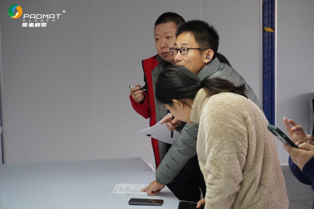 Staff confirming client requirements with documents in professional mouse pad manufacturer’s office.