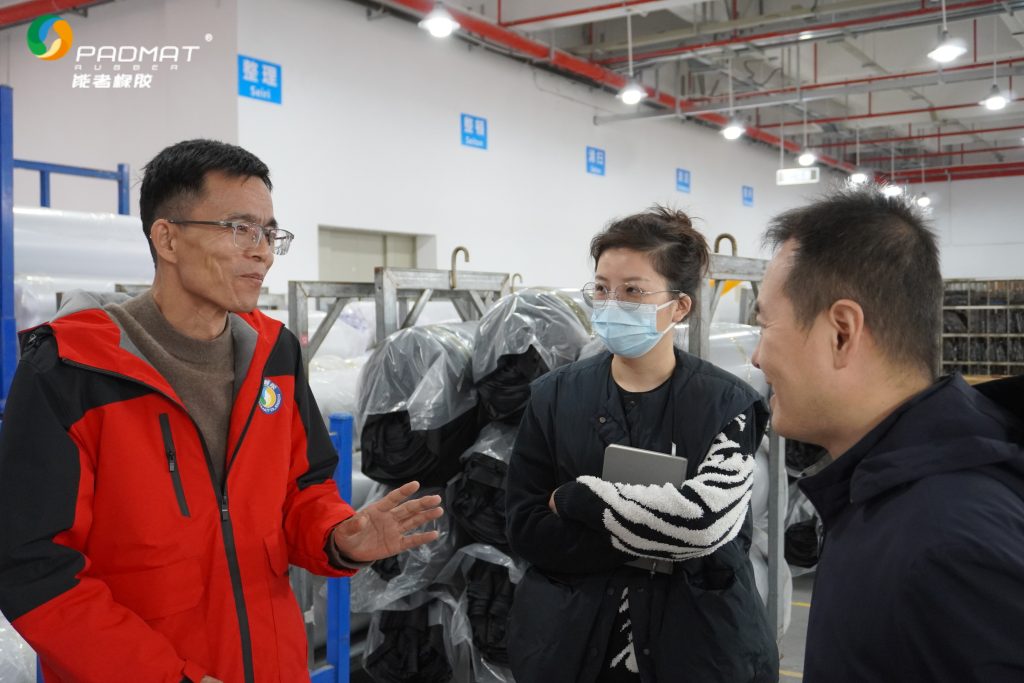 Professional mouse pad manufacturer’s team communicating with clients in production area.