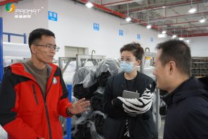 Professional mouse pad manufacturer’s team communicating with clients in production area.