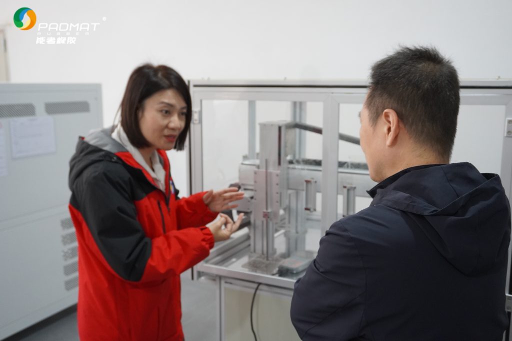 Staff operating testing equipment for quality inspection in professional mouse pad manufacturer's facility.