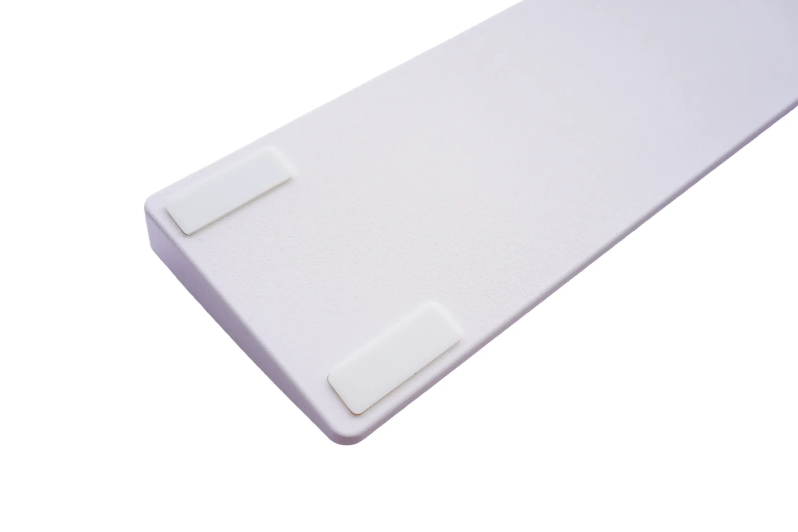 Bottom of keyboard wrist rest with non-slip rubber pads on plastic base for desk stability