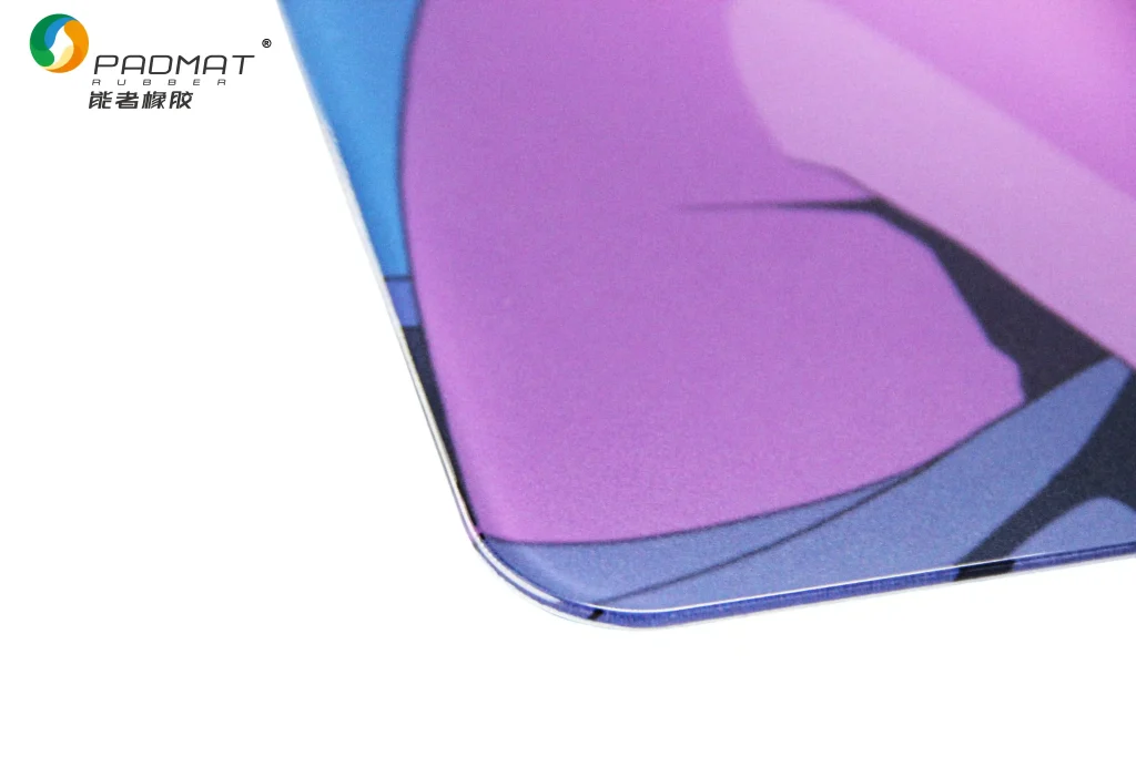 Edge detail display of PADMAT tempered glass gaming mouse pad, showing polished rounded corner and vibrant purple‑blue printed surface