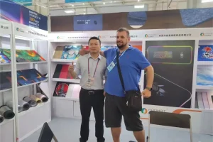 Padmat Rubber mousepad factory exhibition booth with German customer and factory representative, showcasing custom gaming mousepads and RGB desk mats