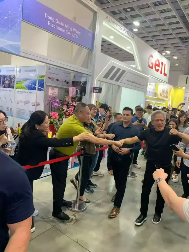 NVIDIA representative shaking hands at Computex Taipei exhibition hall, surrounded by visitors