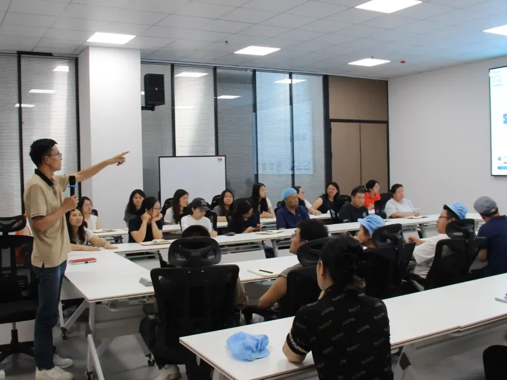 Full view of internal seminar, General Manager Zhou giving concluding speech about tiered training system for all staff