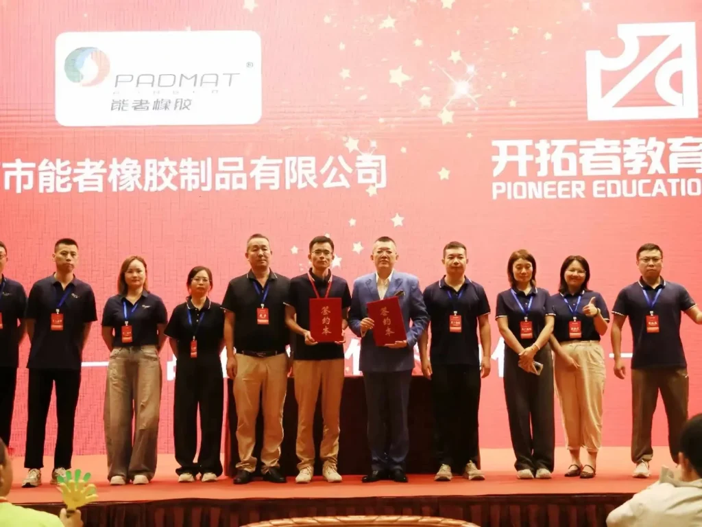 PADMAT core team stands on stage holding cooperation certificates, marking long-term study & management training partnership with Pioneer Educatio