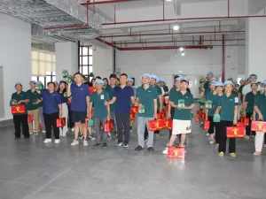 Group photo of all Patmat staff after receiving Dragon Boat Festival benefits, everyone holds festival gift boxes and stands in neat formation