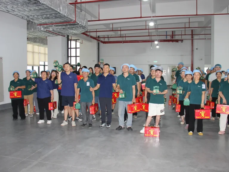 Group photo of all Patmat staff after receiving Dragon Boat Festival benefits, everyone holds festival gift boxes and stands in neat formation