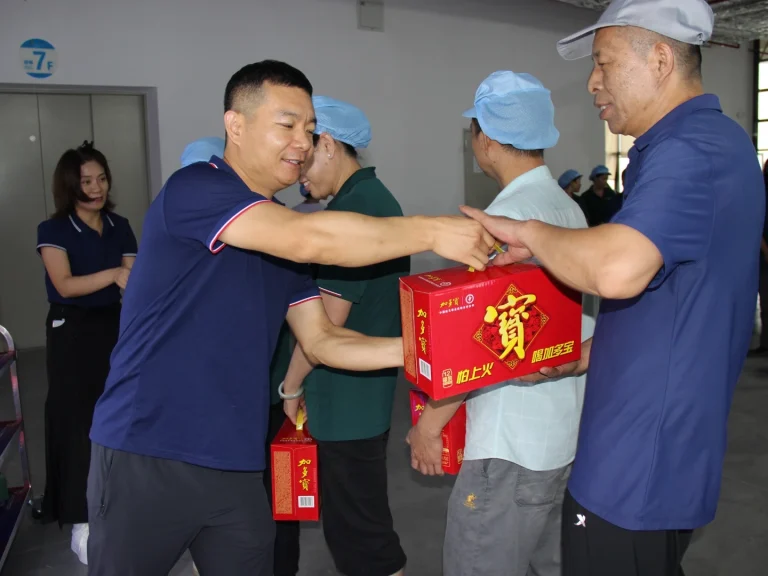 Factory director hands red festival gift box to management cadre at Patmat Dragon Boat Festival activity, all staff enjoy the same holiday welfare