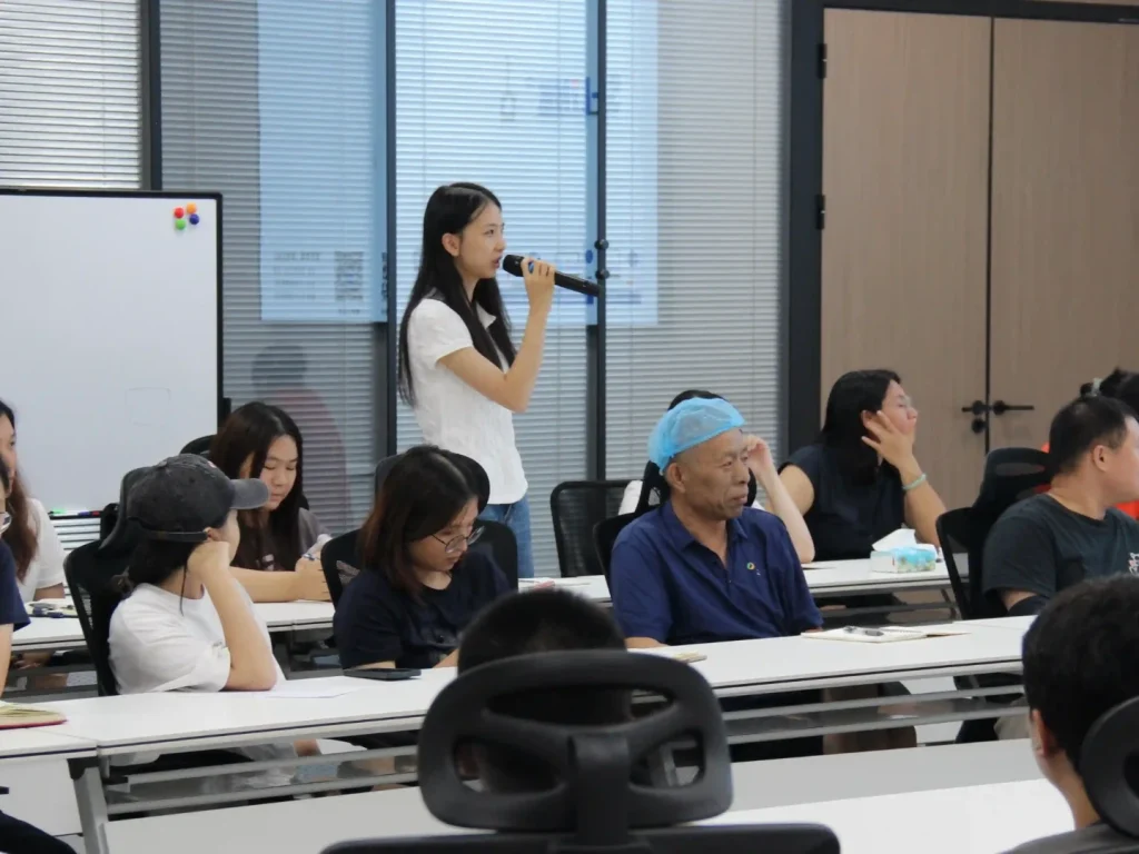 New team member standing with microphone to share entry experience, expressing desire to learn professional skills & management knowledge
