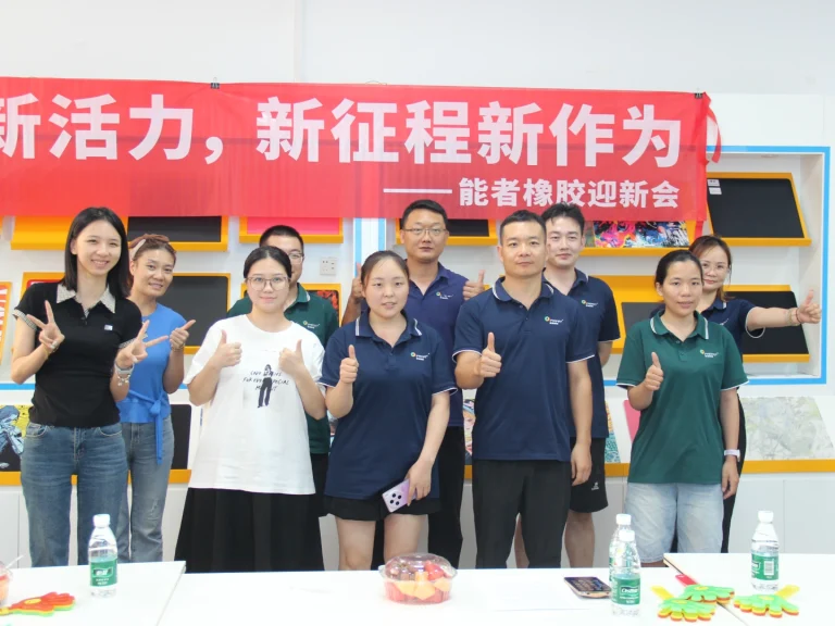 Group photo of management and new employees under the slogan banner "New blood new vitality, new journey new achievement", mouse pad display wall as background