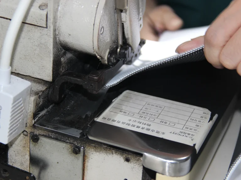 Workers operate edge sewing machine in production workshop to carry out neat border stitching for rubber mouse pads